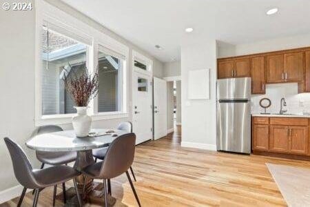 dining area with sink and light hardwood / wood-style flooring