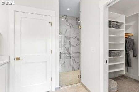 bathroom with tiled shower and tile patterned flooring