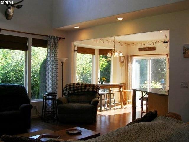 living room with an inviting chandelier and dark wood-type flooring