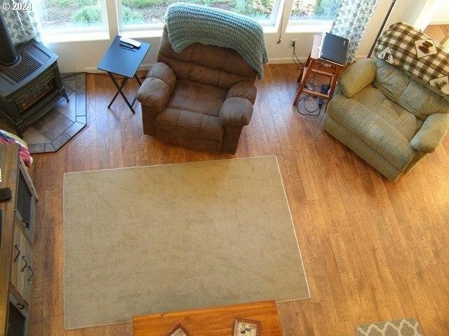 living room with a wood stove and light hardwood / wood-style floors