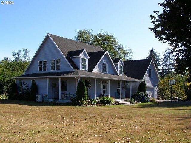 view of front of house with a garage, central AC unit, and a front lawn