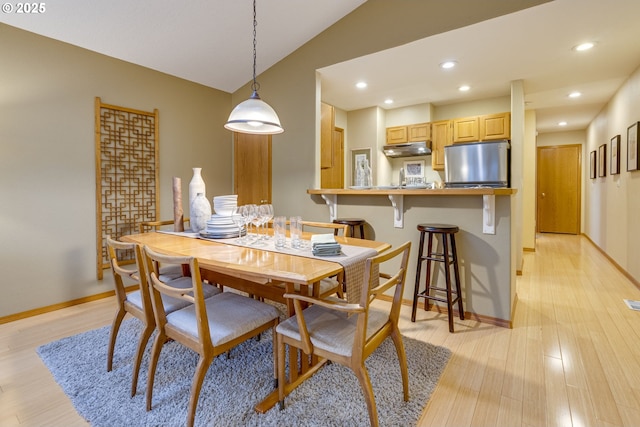 dining room featuring light hardwood / wood-style flooring and vaulted ceiling