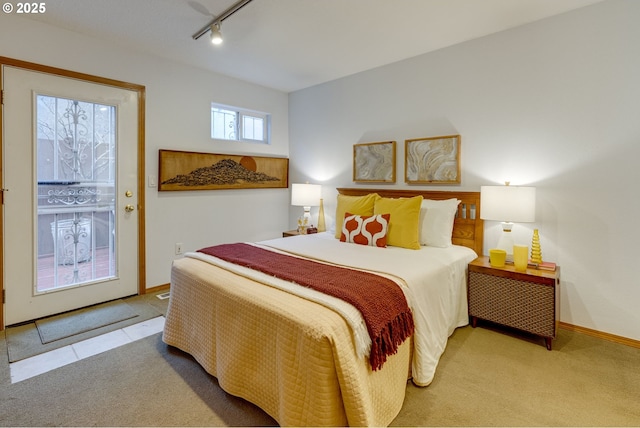 carpeted bedroom with rail lighting and access to outside