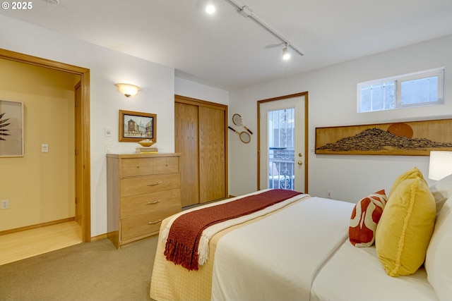 carpeted bedroom featuring a closet and rail lighting