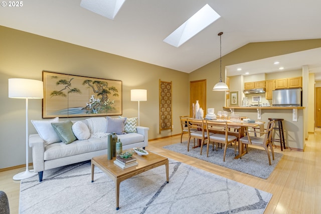 living room featuring light hardwood / wood-style floors and lofted ceiling with skylight