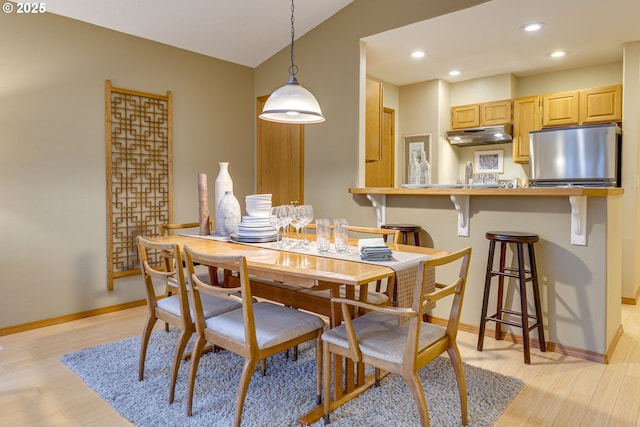 dining space with light hardwood / wood-style flooring and sink