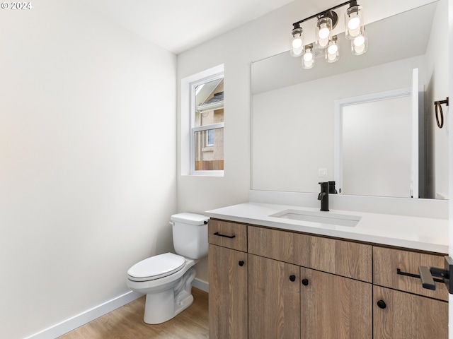 bathroom featuring hardwood / wood-style flooring, vanity, and toilet