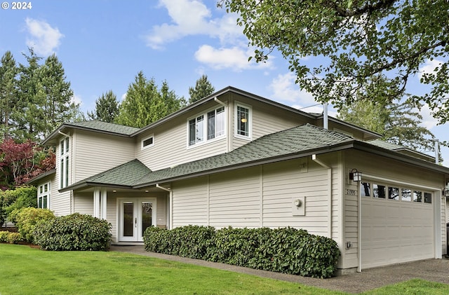 view of front of home with french doors, a front yard, and a garage