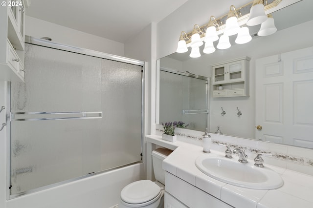 full bathroom with combined bath / shower with glass door, vanity, and toilet