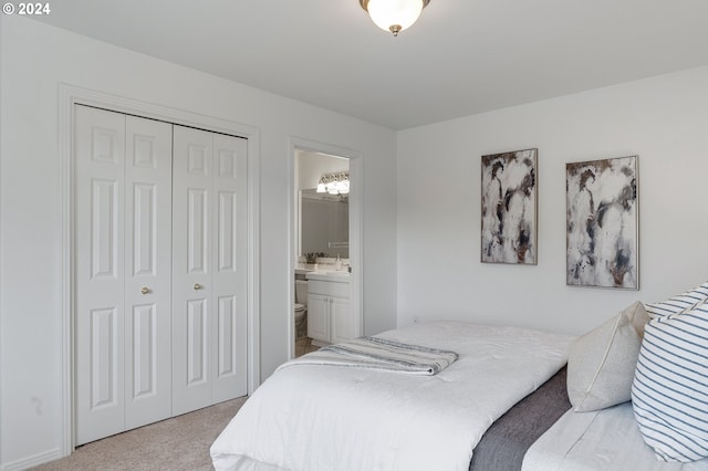 bedroom featuring light carpet, connected bathroom, a closet, and sink