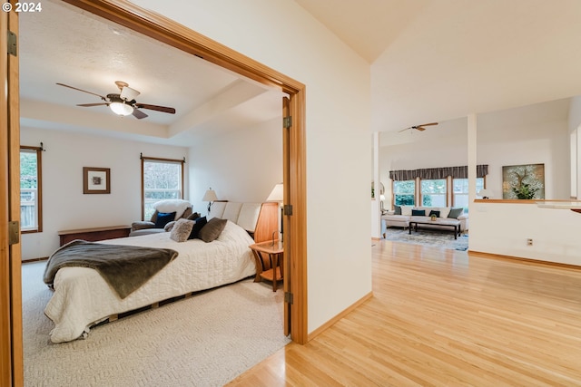 bedroom featuring ceiling fan, light hardwood / wood-style floors, and multiple windows