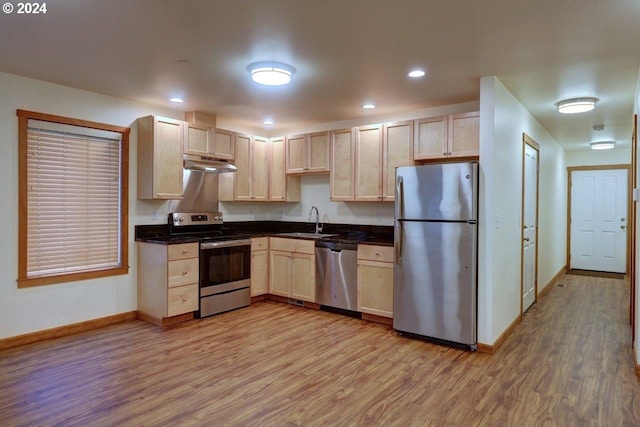 kitchen with light brown cabinetry, appliances with stainless steel finishes, sink, and light hardwood / wood-style floors