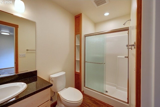 bathroom featuring a shower with shower door, vanity, toilet, and wood-type flooring