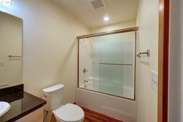 full bathroom with toilet, combined bath / shower with glass door, vanity, and hardwood / wood-style flooring