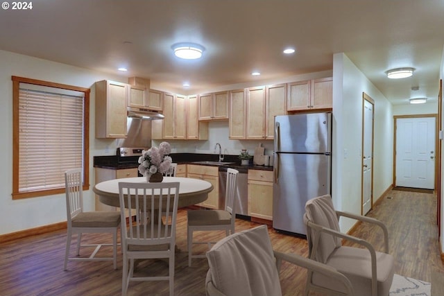720 G Ave Unit D, Seaside, OR 97138 - kitchen with stainless steel appliances, under cabinet range hood, light brown cabinets, a sink, and baseboards