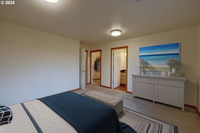 bedroom with light colored carpet and ensuite bath