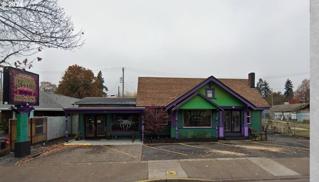 view of front of home featuring fence and uncovered parking