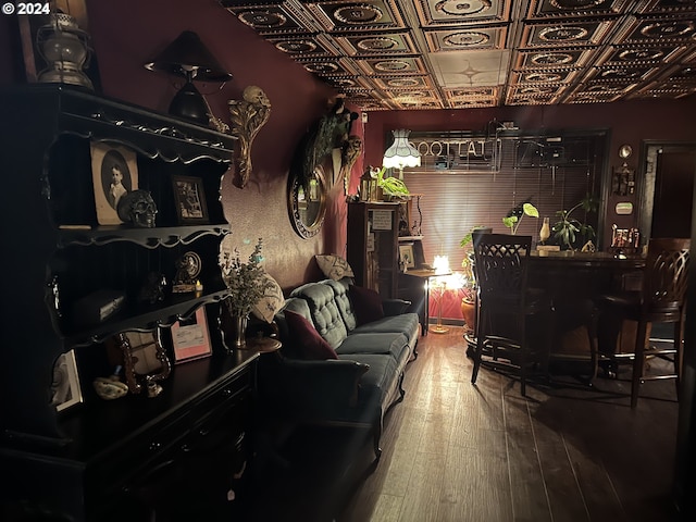 living area with wood-type flooring and an ornate ceiling