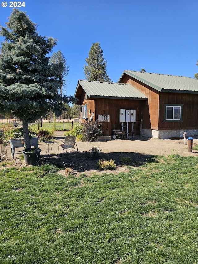 back of house with a yard and metal roof