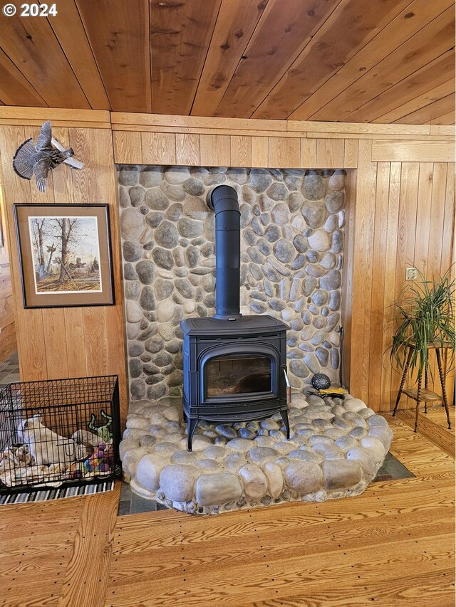 details with wooden walls, a wood stove, and wood ceiling