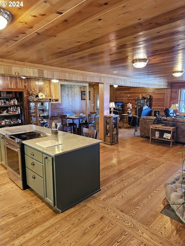 kitchen featuring stainless steel electric range oven, wooden ceiling, wooden walls, and green cabinets