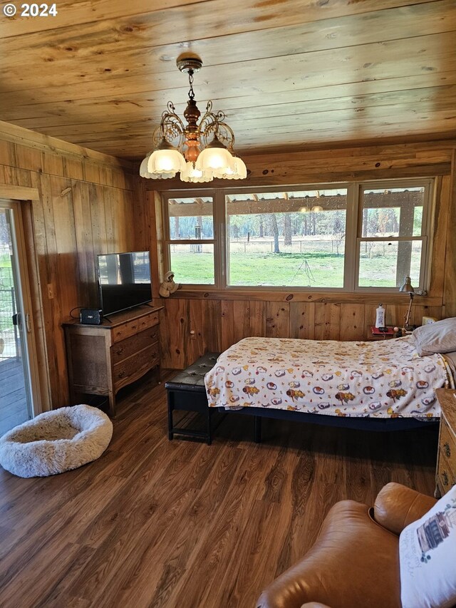 bedroom with wood ceiling, dark hardwood / wood-style floors, access to outside, a notable chandelier, and wood walls