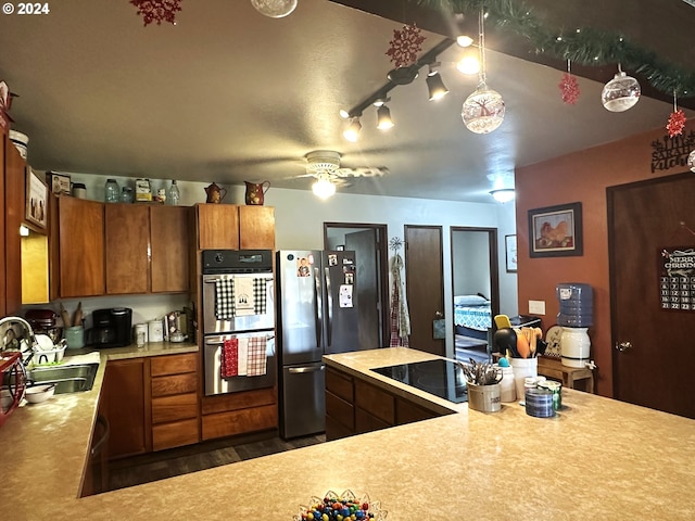 kitchen featuring ceiling fan, sink, stainless steel appliances, and dark wood-type flooring