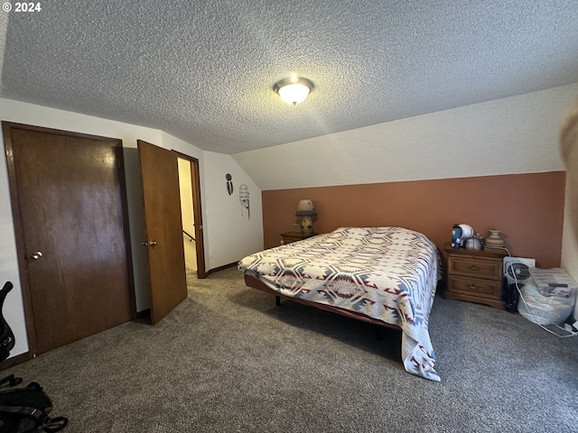 bedroom featuring lofted ceiling, carpet floors, and a textured ceiling