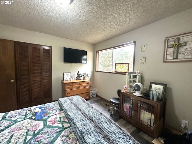 bedroom featuring a textured ceiling, a closet, and dark hardwood / wood-style floors