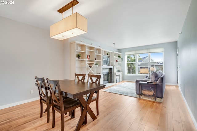 dining space featuring a premium fireplace and light wood-type flooring