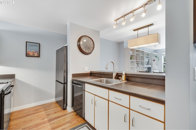 kitchen with sink, black electric range, stainless steel fridge, dishwasher, and white cabinets