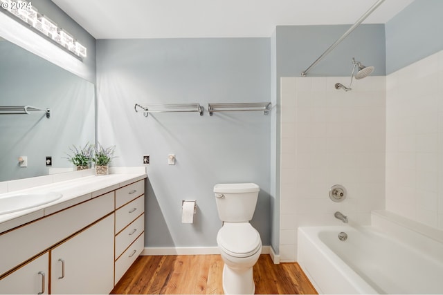 full bathroom with vanity, toilet, tiled shower / bath combo, and hardwood / wood-style floors