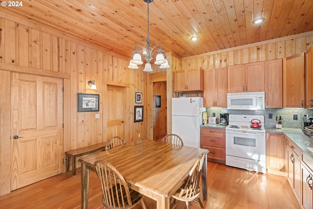 kitchen with tasteful backsplash, light stone counters, white appliances, wooden walls, and light hardwood / wood-style flooring