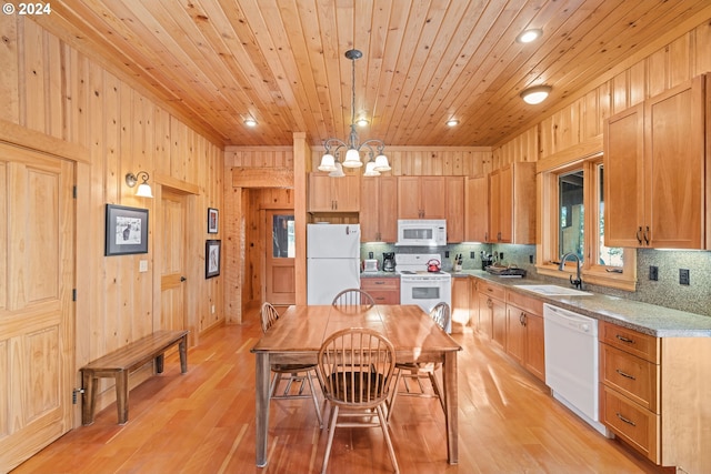 kitchen featuring wood walls, light wood-type flooring, white appliances, and tasteful backsplash