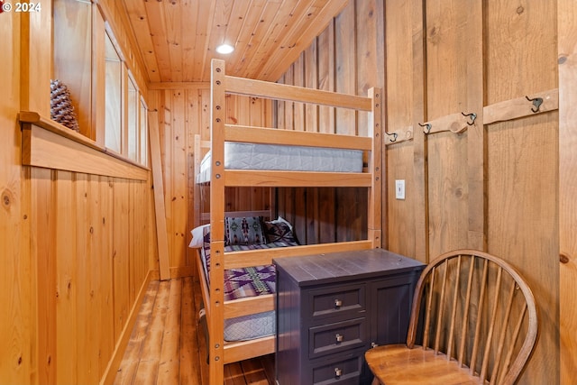 bedroom featuring hardwood / wood-style floors, wooden ceiling, and wooden walls