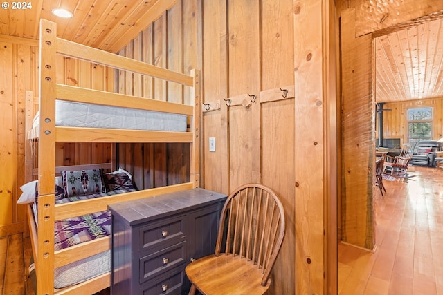 bedroom featuring light hardwood / wood-style flooring, wood ceiling, and wood walls