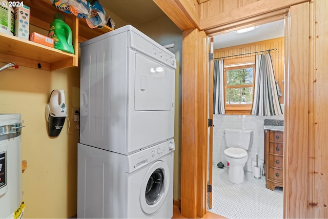 washroom featuring tile patterned flooring and stacked washer / dryer