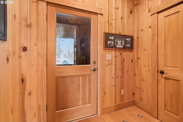 doorway to outside with wooden walls and wood-type flooring