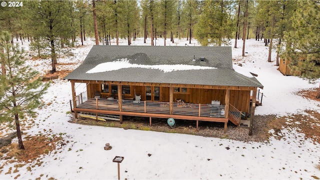 snow covered house featuring a deck