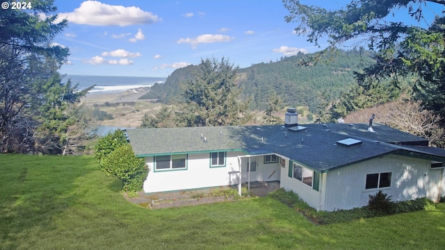 back of house with a lawn and a water and mountain view