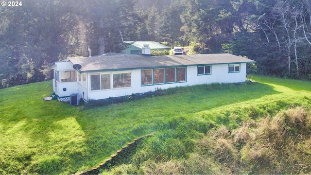 exterior space with a sunroom, cooling unit, and a front yard