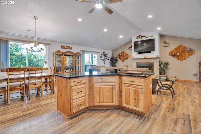 kitchen with ceiling fan with notable chandelier, decorative light fixtures, a center island, light hardwood / wood-style floors, and lofted ceiling