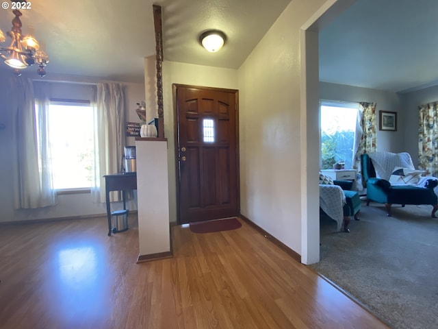 entryway with wood-type flooring and a notable chandelier