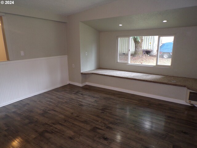 spare room with a textured ceiling and dark wood-type flooring