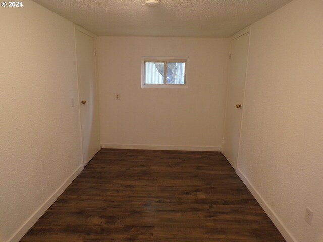 unfurnished room featuring a textured ceiling and dark wood-type flooring