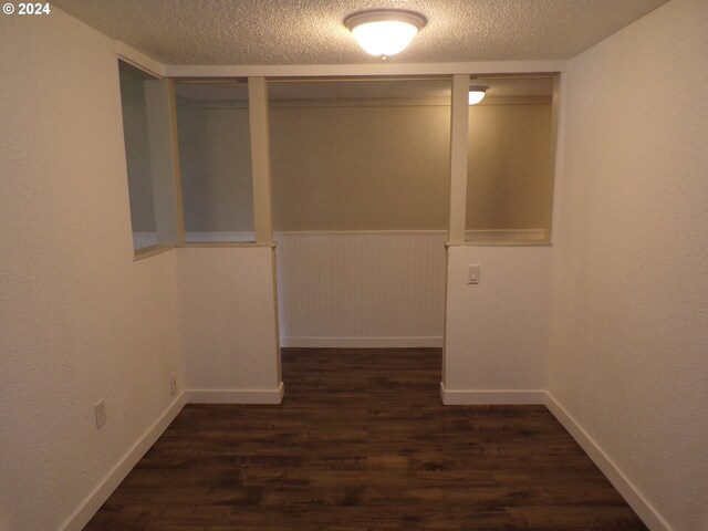 hallway featuring a textured ceiling and dark wood-type flooring