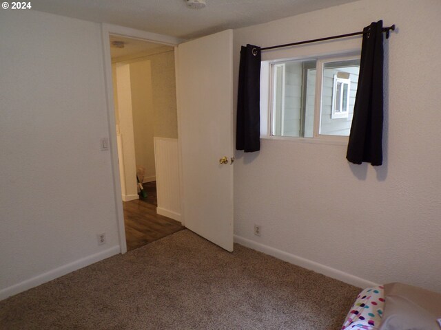 unfurnished bedroom with dark carpet