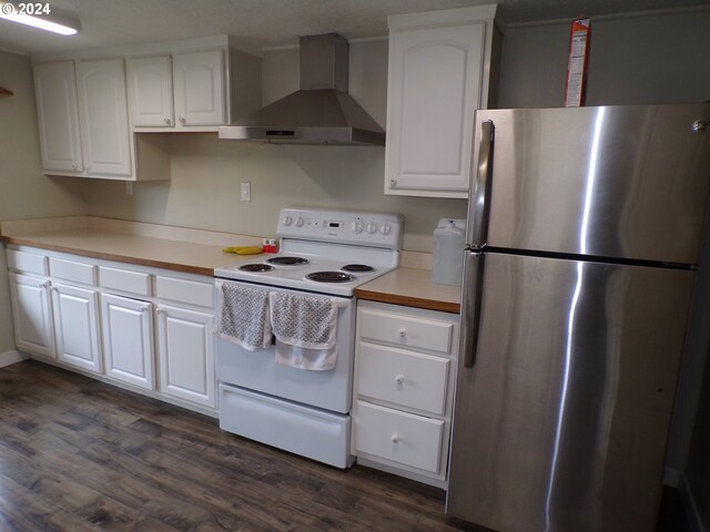 kitchen featuring stainless steel refrigerator, wall chimney range hood, dark hardwood / wood-style flooring, electric stove, and white cabinets