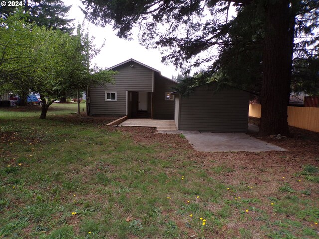 back of house with a patio area and a lawn