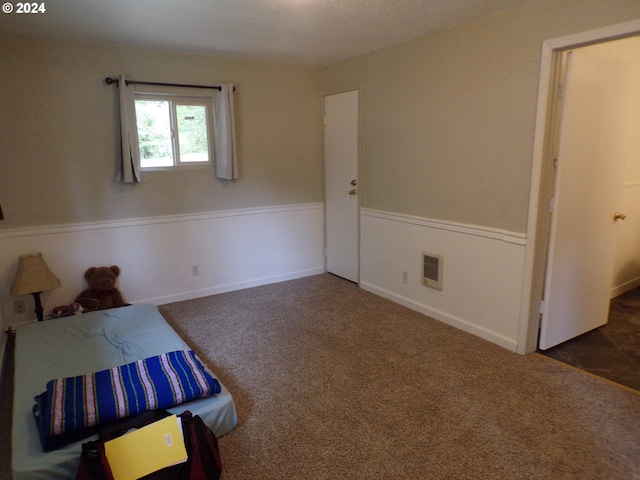 unfurnished bedroom featuring dark carpet and a textured ceiling